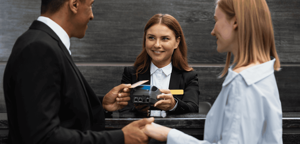 Receptionist scanning guest pass at gym check-in counter.